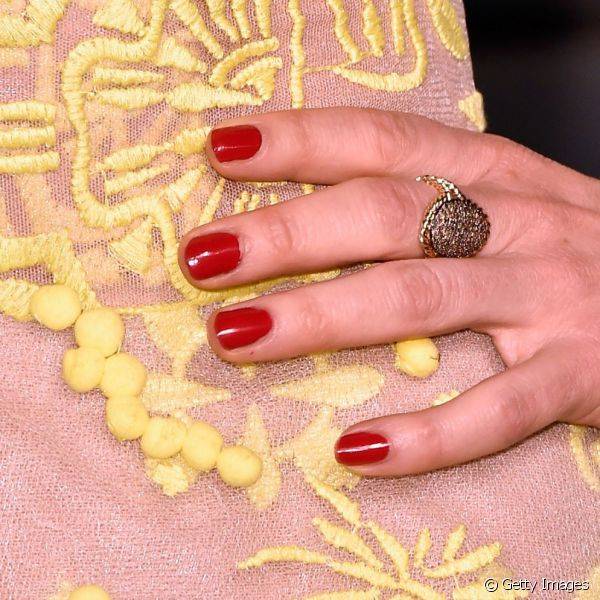 Juliette Lewis usou um esmalte vermelho para realçar seu vestido nude com detalhes amarelos escolhido para a festa pós-Oscar da Vanity Fair